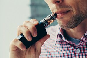 man vaping, risking hearing loss