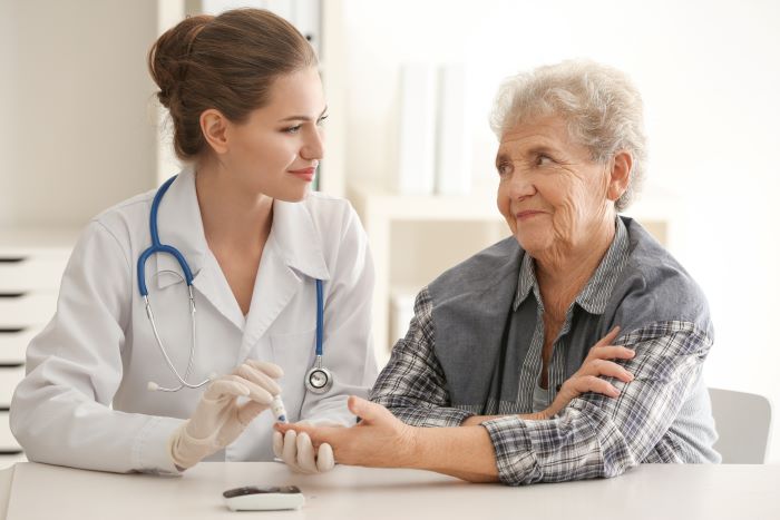 Doctor measuring blood sugar level of diabetic patient suffering from hearing loss
